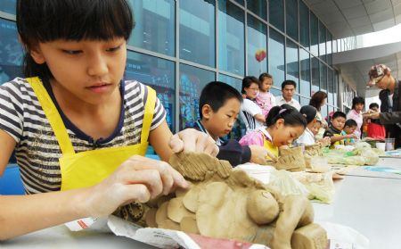 Pupil visitors make their artistic pottery and porcelain works in the international ceramic art expo in Zibo, one of the five major ceramic cities in east China's Shandong Province, Sept. 6, 2009.[Dong Naide/Xinhua]