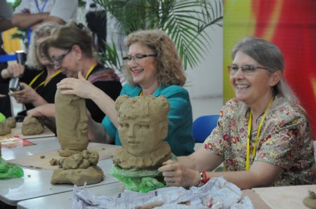 International visitors view artistic pottery and porcelain works in the international ceramic art expo in Zibo, one of the five major ceramic cities in east China's Shandong Province, Sept. 6, 2009. [Zhang Qunqun/Xinhua]