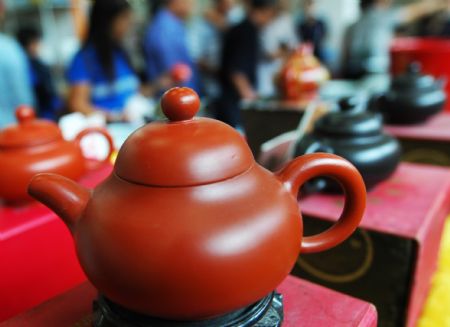 Visitors buy artistic pottery and porcelain works in the international ceramic art expo in Zibo, one of the five major ceramic cities in east China's Shandong Province, Sept. 6, 2009.[Dong Naide/Xinhua]