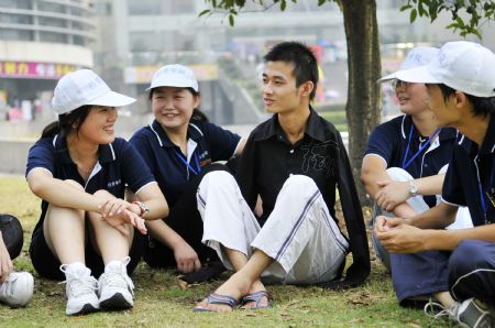 Young man without arms Yang Bin (C) talks with his schoolmates on the first day of the new term at Three Gorges University in Yichang, central China's Hubei province, Sept. 6, 2009.[Huang Xiang/Xinhua]