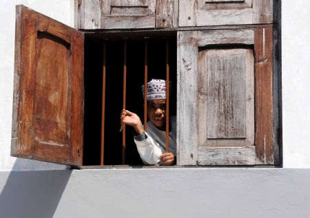 Photo taken on Sept. 2, 2009 shows a girl looking out from a window in Zanzibar Stone Town in Tanzania.[Xu Suhui/Xinhua]