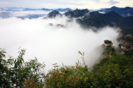 Photo taken on Sept. 6, 2009 shows the spectacular scene of vaporing and rosy cloud sea weltering over the mountain peaks, a rare scenery after the early Autumn rainfall, in the Xizha Village, in the suburb of Huairou District, Beijing. [Bu Xiangdong/Xinhua]