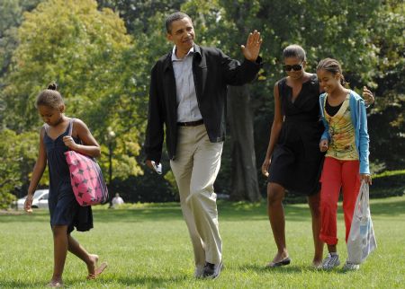 U.S. President Barack Obama (2nd L), with his wife Michelle (2nd R) and daughters Malia (R) and Sasha (L), waves as he returns from his summer vacation to the White House in Washington, September 6, 2009.[Xinhua/Reuters]