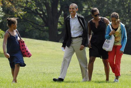 U.S. President Barack Obama (2nd L), with his wife Michelle (2nd R) and daughters Malia (R) and Sasha (L), waves as he returns from his summer vacation to the White House in Washington, September 6, 2009.[Xinhua/Reuters]