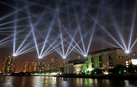 Photo taken on Sept. 6, 2009 shows the dazzling searchlight intersection as the National Day Celebration nocturnal illuminations are in the process of readjustment, along the bank of the Suzhou River, in downtown Shanghai, east China.[Xinhua] 