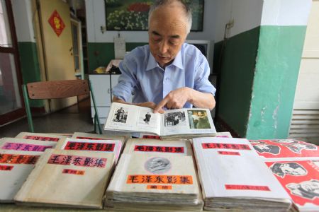 Retired engineer Liu Kezhu shows his collections of pictures of late Chinese leader Chairman Mao Zedong (1893-1976) in Xiangfan, central China's Hubei province, Sept. 6, 2009. Liu, a retired senior engineer of the Jianghua Machinery Factory in Xiangfan, has collected more than 1,500 pictures of Chairman Mao. (Xinhua/Yu Xiang)