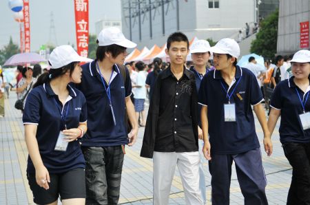 Young man without arms Yang Bin (C) walks with his schoolmates on the first day of the new term at Three Gorges University in Yichang, central China's Hubei province, Sept. 6, 2009. Eighteen-year-old Yang Bin from a farmer's family, who lost his two arms in an accident at the age of two and began learning to eat and drink, to put on dress and to write with his foot, finished his primary and secondary school education and finally was enrolled at School of Economics and Management of Three Gorges University. (Xinhua/Huang Xiang)