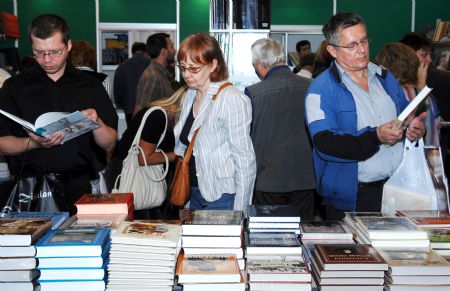 Visitors read books in the 22nd Moscow International Book Fair in Moscow, capital of Russia, Sept. 6, 2009.(Xinhua/Liu Kai)