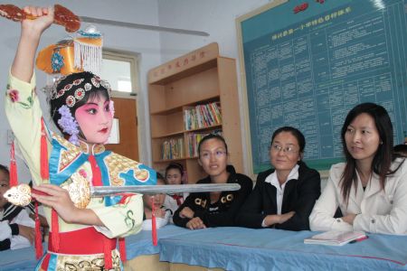 Pupil Gong Nuo plays Beijing Opera for teachers at the First Primary School in Boxing County, east China's Shandong Province, Sept. 7, 2009. On the eve of Chinese Teacher's Day, which falls on Sept. 10, pupils of this school sent greetings and best wishes to their teachers.(Xinhua/Chen Bin) 