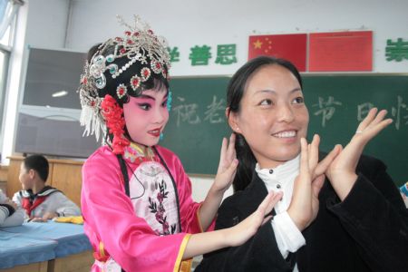 Pupil Yan Shuting plays Beijing Opera with her teacher at the First Primary School in Boxing County, east China's Shandong Province, Sept. 7, 2009. On the eve of Chinese Teacher's Day, which falls on Sept. 10, pupils of this school sent greetings and best wishes to their teachers.(Xinhua/Chen Bin)