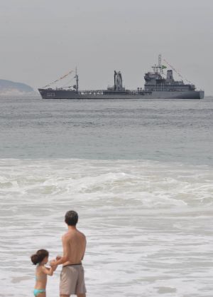 A girl with her father look at the marine parade held off the Copacabana Beach of Rio de Janeiro, Brazil, September 7, 2009.[Song Weiwei/Xinhua]