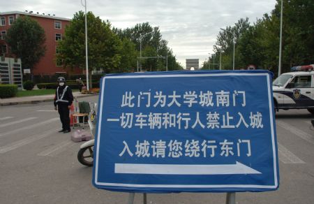 A notice board that advises people and vehicles to avoid entering is set up at an entrance to the university town in Langfang, northern China's Hebei Province, Sept. 7, 2009.[Gong Zhihong/Xinhua]