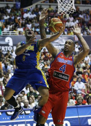 Alex Garcia (L) of Brazil is fouled by Peter John Ramos of Puerto Rico during the first half of their men's FIBA Americas Championship gold medal final basketball game in San Juan September 6, 2009.(Xinhua/Reuters Photo) 