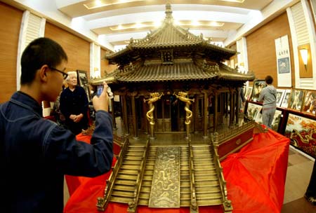 A visitor takes snapshot of the giant bronze sculpture of the Dazheng Hall (Hall of Great Affairs) of the Shenyang-located Imperial Palace of Qing Dynasty, on its public show in Shenyang City, northeast China's Liaoning Province, Sept. 6, 2009.