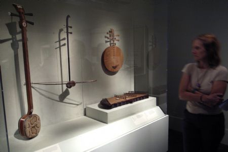Visitors look at a Chinese traditional musical instrument at an exhibition named Silk and Bamboo: Music and Art of China in the Metropolitan Museum of Art, New York, Sept. 5, 2009.(Xinhua/Liu Xin)