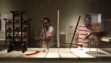 Visitors look at a Chinese traditional musical instrument at an exhibition named Silk and Bamboo: Music and Art of China in the Metropolitan Museum of Art, New York, Sept. 5, 2009.(Xinhua/Liu Xin) 