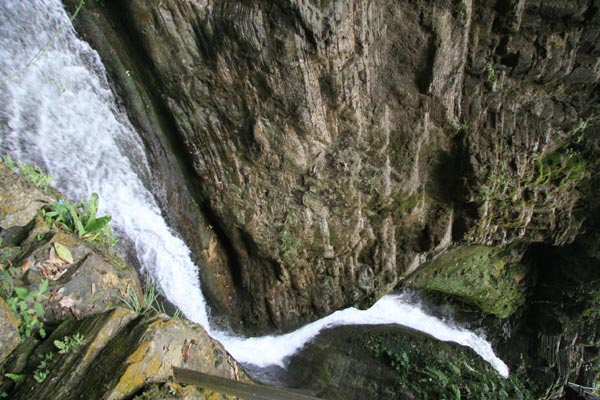 A waterfall sneaks trough the rock wall in Tianlong Canyon, Hunan Province. [Photo:CRIENGLISH.com/ Duan Xuelian]