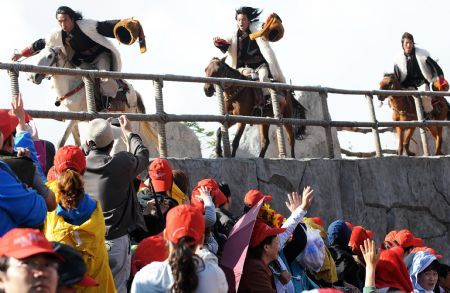 People watch the performance 'Impression Lijiang' staged near the foot of the Yulong Snow Mountains in Lijiang, a tourist resort in southwest China's Yunnan Province, Sept. 5, 2009. 