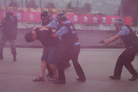 A 'terrorist' is arrested in an anti-terrorism drill at the Three Gorges area in Yichang, central China's Hubei Province, Sept. 8, 2009.(Xinhua/Li Kaiyong)