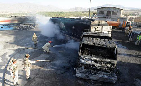 Firemen try to put out a blaze on one of the trucks carrying supplies to western forces that were attacked in Quetta September 8, 2009. [Xinhua/AFP]