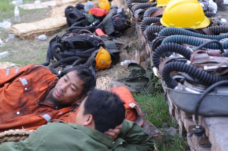 Succors have a rest after their rescue work at the Xinhua No. 4 coal mine in Xinhua District of Pingdingshan City, central China's Henan Province, on Sept. 8, 2009. A total of 93 people were working in the coal mine where a gas explosion happened Tuesday morning, leaving at least 35 dead.[Zhaojiuyuan Peng/Xinhua] 