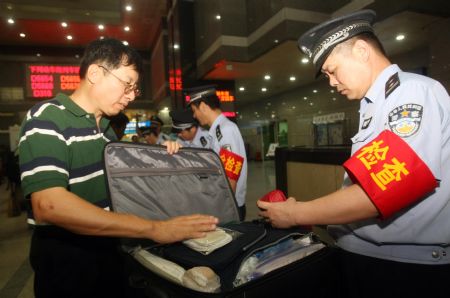 A policeman conducts security check on a passenger's hand luggage at the Hangzhou Railway Station, in east China's Zhejiang province, Sept. 8, 2009. A series of strict security measures have been taken as the 60th anniversary of the founding of the People's Republic of China approaches.[Xinhua] 