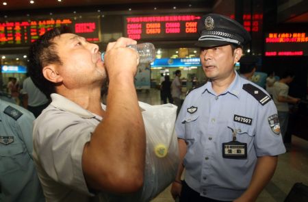 A passenger receives security check to his drinks that would be brought aboard the coaches at the Hangzhou Railway Station, in east China's Zhejiang province, Sept. 8, 2009.[Xinhua]
