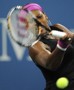 Serena Williams of the United States smashes a backhand to Flavia Pennetta of Italy during their evening match at the U.S. Open tennis championship in New York, September 8, 2009.(Xinhua/Reuters Photo) 