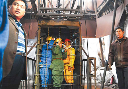 Rescuers take an elevator down into a coal mine Tuesday looking for missing miners in Pingdingshan, Henan province. An explosion at the illegal mine killed 35 miners and left another 44 trapped, government officials said. [Zhao Peng/China Daily] 