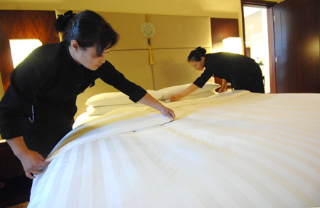 Waitresses prepare the bedroom for Klaus Schwab, founder and chairman of the World Economic Forum (WEF), at the Shangrila Hotel in Dalian, northeast China&apos;s Liaoning Province, September 7, 2009. [Xinhua]