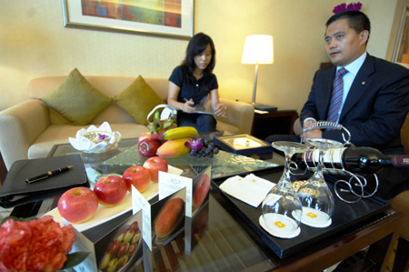 Staff members of the Shangrila Hotel discuss the preparation of fresh fruites at the suite-room for Klaus Schwab, founder and chairman of the World Economic Forum (WEF), at the Shangrila Hotel in Dalian, northeast China&apos;s Liaoning Province, September 7, 2009. [Xinhua]