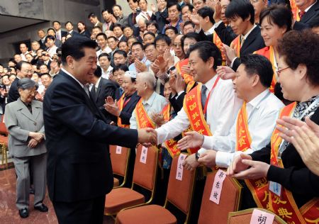 Jia Qinglin (FRONT L), chairman of the National Committee of the Chinese People's Political Consultative Conference, shakes hands with representatives at a meeting to honor 73 outstanding figures who have done well in the fight against poverty in Beijing, capital of China, on Sept. 9, 2009. (Xinhua/Li Xueren)  