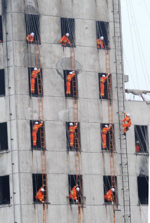 Firefighters climb a building during a security and rescue drill in Changsha, capital of central China's Hunan Province Sept. 9, 2009.(Xinhua/Long Hongtao)
