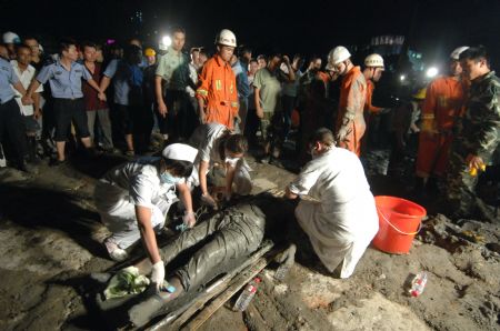 Medical workers give first aid to an injured worker at a construction site in Taizhou City, east China's Zhejiang Province, Sept. 9, 2009. A huge slurry pool at a construction site in Taizhou collapsed on Wednesday, causing at least seven people dead. Rescuers are still clearing the site. (Xinhua/