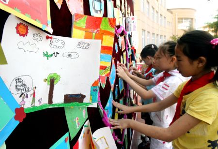 Pupils at Meilong Central School put their self-made special cards for teachers on a wall in Shanghai, east China, Sept. 10, 2009.(Xinhua