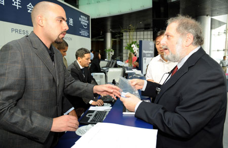 Denis F. Simon (R), director of the Program on US-China Technology, Economic and Business Relations of the School of International Affairs, Penn State University from the United States of America, registers for the Annual Meeting of the New Champions 2009, or Summer Davos, in Dalian, northeast China's Liaoning Province. [Li Gang/Xinhua]