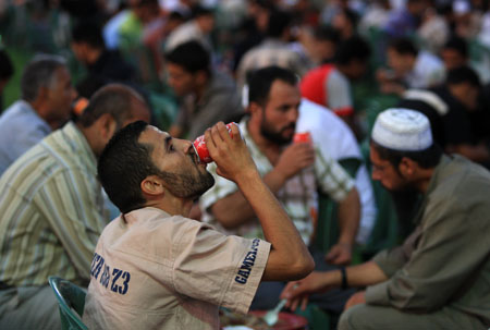 Palestinian Muslims attend a collective meal after the sunset prayer during the holy month of Ramadan in Gaza City, Palestine, Sept. 9, 2009. [Wissam Nassar/Xinhua]