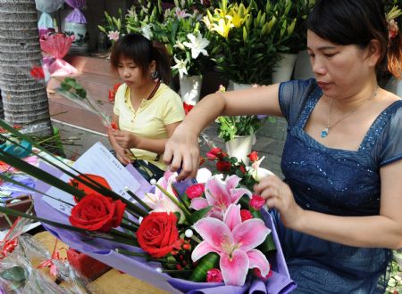 Stuff members at a florist prepare with bunches of flowers in Xiamen, southeast China's Fujian Province, Sept. 10, 2009. It was the Teachers' Day on Thursday and lots of students chose flowers as a sweet gift for teachers, stimulating high demands for fresh flowers during the Teachers' Day. [Zhang Guojun/Xinhua]