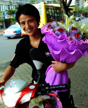 A staff member from a florist delivers flowers for customers in Xiamen, southeast China's Fujian Province, Sept. 10, 2009.[Zhang Guojun/Xinhua]