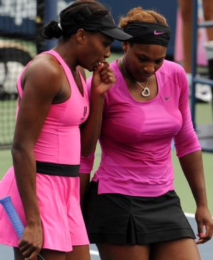Venus and Serena Williams (R) of the US talk during the women's doubles quarter final against Zheng Jie and Yan Zi of China at the U.S. Open tennis tournament in New York, the U.S., Sept. 9, 2009. Venus and Serena Williams won the match 2-0. (Xinhua/Shen Hong)