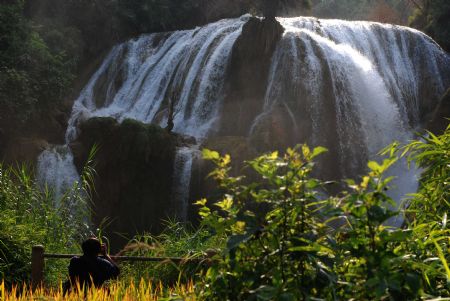 Photographers shoots the Sanla waterfalls in Guangnan County, Zhuang and Miao Autonomous Prefecture of Wenshan Autonomous Prefecture, southwest China's Yunnan Province, Sept. 6, 2009. With a fall of 120m, the Sanla waterfalls was also called 'echo spring' waterfalls. (Xinhua/Chen Haining) 