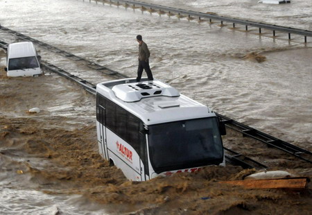 A man on a partially submerged bus waits for evacuation on a highway in Istanbul September 9, 2009.