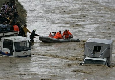 Rescue workers evacuate passengers who were trapped in a bus in Ikitelli, Istanbul, Turkey, Wednesday, Sept. 9, 2009