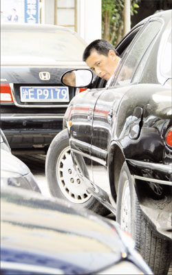 Guard Gao Henglun reverses a car carefully at Huajiao Apartments. [Shanghai Daily]