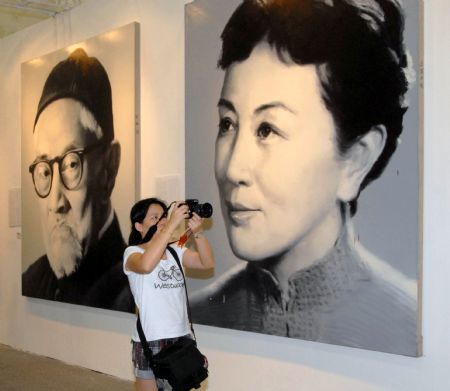 A visitor takes photos of the exhibits during the ongoing 13th Shanghai Art Fair, which opens at the Shanghai Mart, in Shanghai, east China, Sept. 9, 2009. 