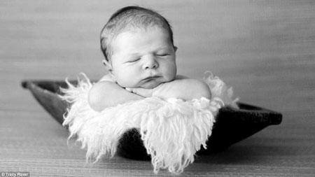 A newborn sleeping in a fruit bowl lined with fleece takes adorable to a new 