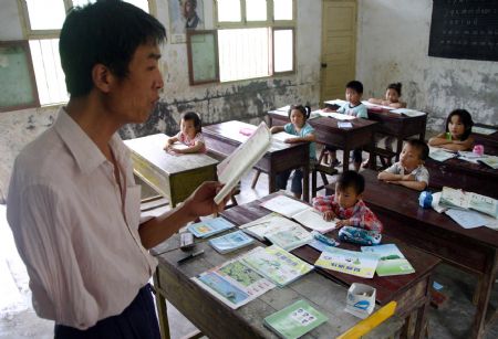  Shao Jun gives a class to pupils at Dongshan Primary School in Sanbing Township of Chaohu City, east China's Anhui Province, Sept. 8, 2009. Shao, 42 years old, lost his right arm during an accident at the age of 19. He started teaching at Dongshan Primary School in 1998 and spent 11 years there. As high-grade pupils were gradually transferred to downtown schools, there is one class in the school with only eight pupils.(Xinhua)