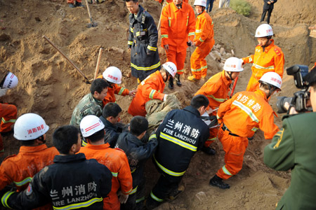 Rescuers conduct operations at the landslide site where several people were buried on a road in Lanzhou, capital of northwest China's Gansu Province, Sept. 14, 2009. The accident happened in the early morning. (Xinhua/Nie Jianjiang)