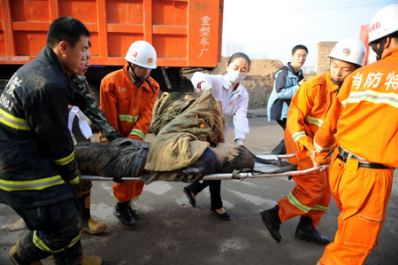 Rescuers carry a wounded person away from the landslide site where several people were buried on a road in Lanzhou, capital of northwest China's Gansu Province, Sept. 14, 2009. (Xinhua/Nie Jianjiang)