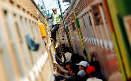 Passengers get on a train at Senen Railway Station in Jakarta, capital of Indonesia, Sept. 13, 2009. Some 17 million Indonesians will travel to home to celebrate the Eid-ul-Fitr festival, which falls on Sept. 21 in Indonesia. [Yue Yuewei/Xinhua]